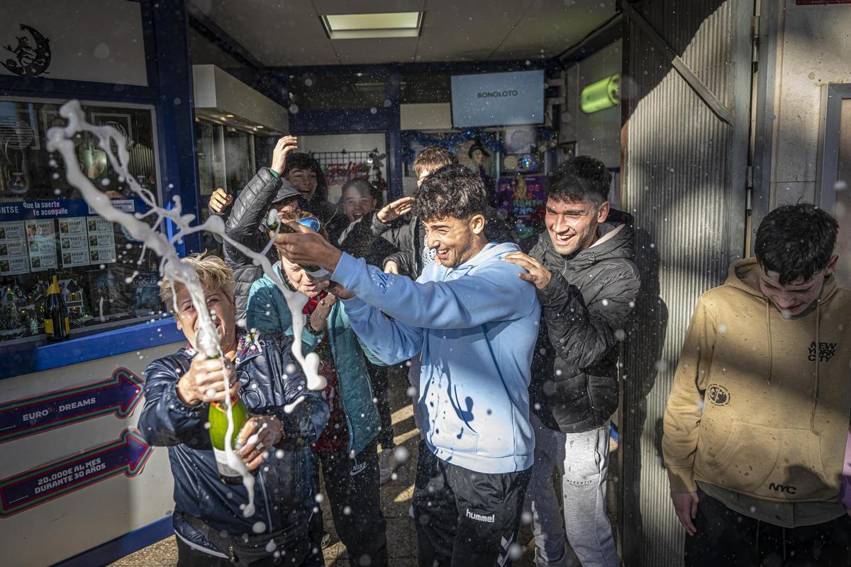 Vecinos de Les Planes (Sant Joan Despí) celebran el segundo premio de la Lotería de Navidad repartido por la administración lotera del barrio.