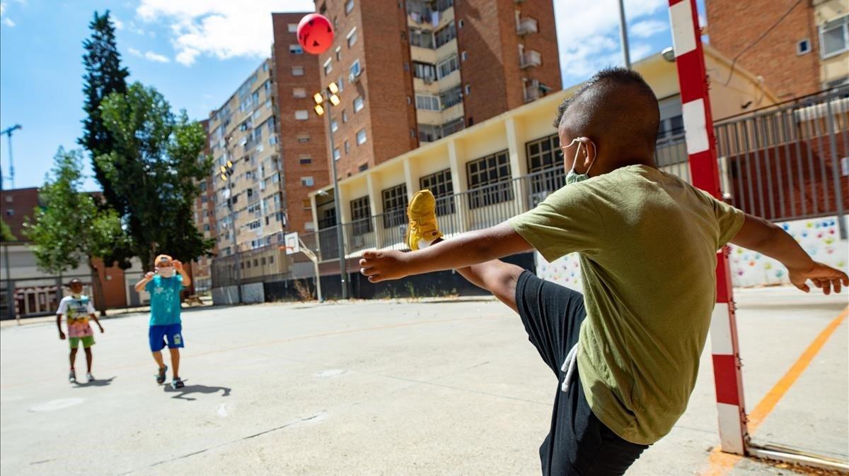 Niños jugando en el casal de verano,que organiza los ’Casals urbans Baobab’,en la Escola SEAT del barrio de La Marina.