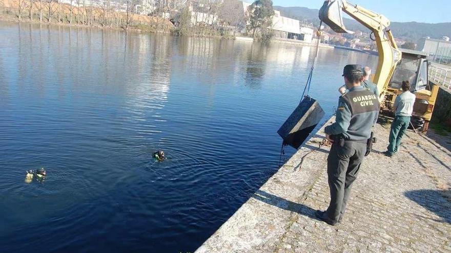 La Guardia Civil recupera una de las máquinas de tabaco arrojadas al río Ulla. // G. Civil