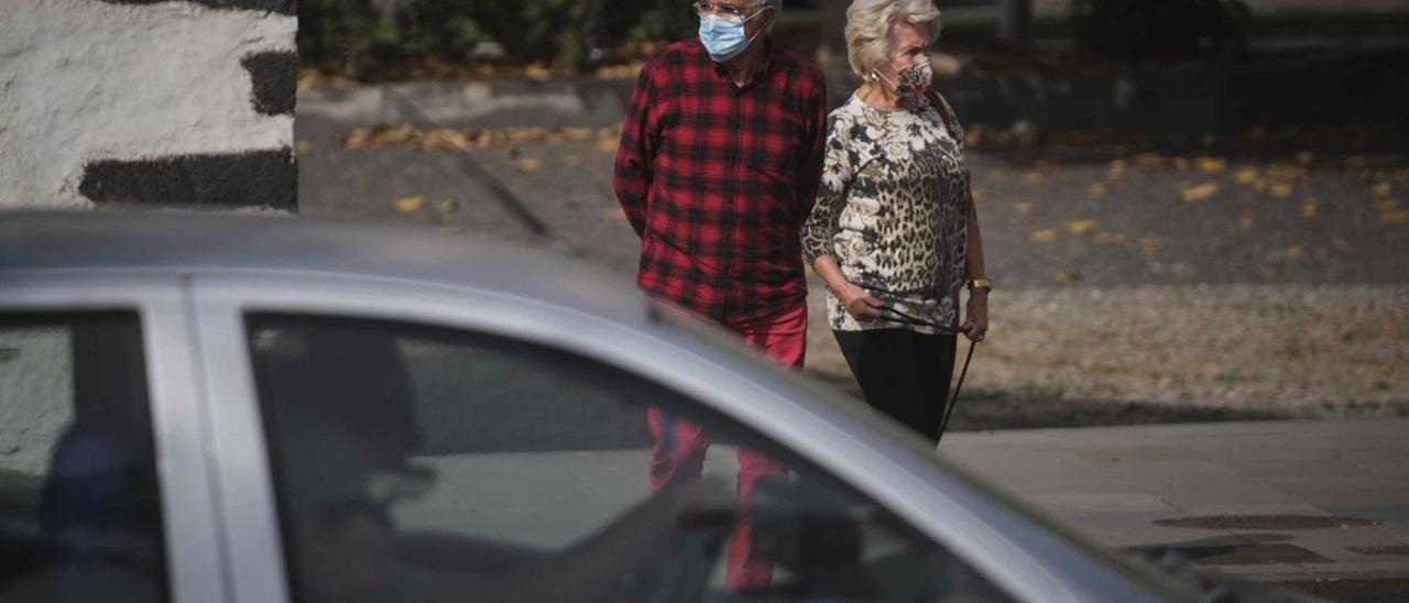 Dos personas mayores con mascarilla pasean por Santa Cruz.