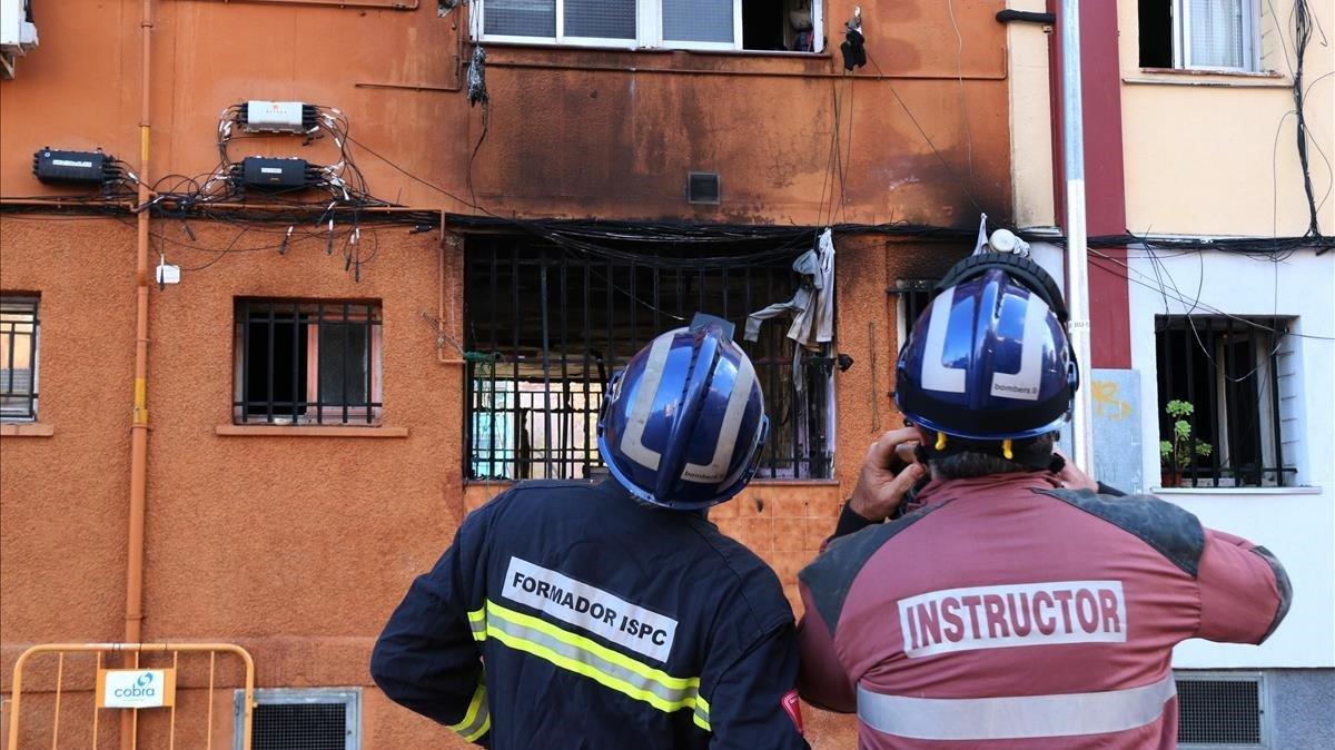 Bomberos de la Generalitat inspeccionan el edificio incendiado en Badalona, el 7 de enero.