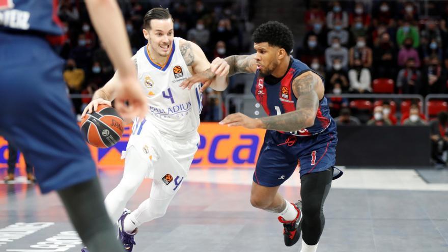 El base estadounidense del Baskonia Lamar Peters (d) lucha con el base francés del Real Madrid Thomas Heurtel.