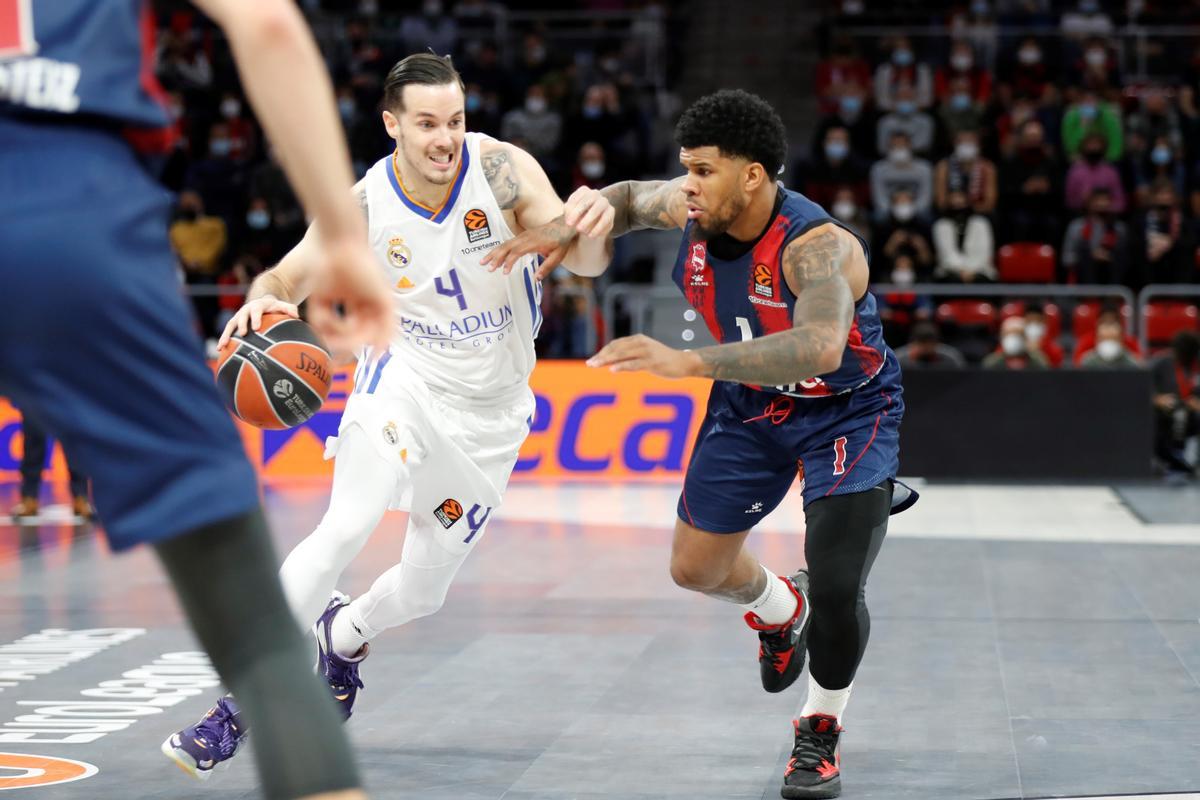 El base estadounidense del Baskonia Lamar Peters (d) lucha con el base francés del Real Madrid Thomas Heurtel.