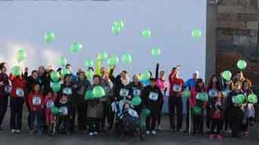 Los participantes en la marcha de Villaescusa sueltan globos a la salida, en el frontón de la localidad.