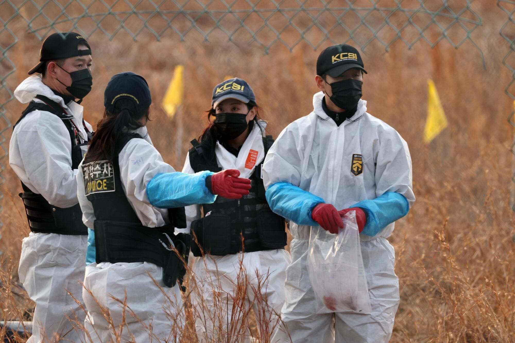 Muan (South Korea), 29/12/2024.- Members of Korea Crime Scene Investigation (KCSI) search around the wreckage of the Jeju Air aircraft at Muan International Airport in Muan, 288 kilometers southwest of Seoul, South Korea, 29 December 2024. According to the National Fire Agency, a passenger jet carrying 181 people erupted in flames after going off the runway at an airport in South Korea's southwestern county of Muan on 29 December, leaving at least 62 people dead. (Corea del Sur, Seúl) EFE/EPA/HAN MYUNG-GU