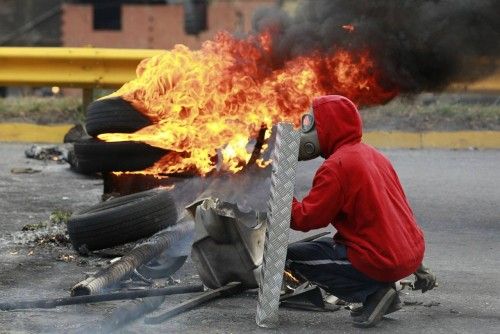 An anti-government protester, covers himself with a shield during a protest against President Nicolas Maduro's government in Caracas