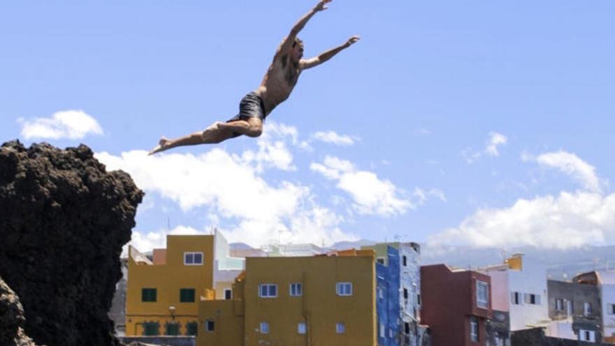 Un joven se lanza al mar ayer en la costa de Punta Brava en Puerto de la Cruz.