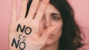 Una mujer levanta la mano en señal de protesta con el mensaje: No es no