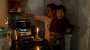 La hermana y el sobrino de Eber Espino, de dos años, en la cocina de la vivienda con un camping gas improvisado.