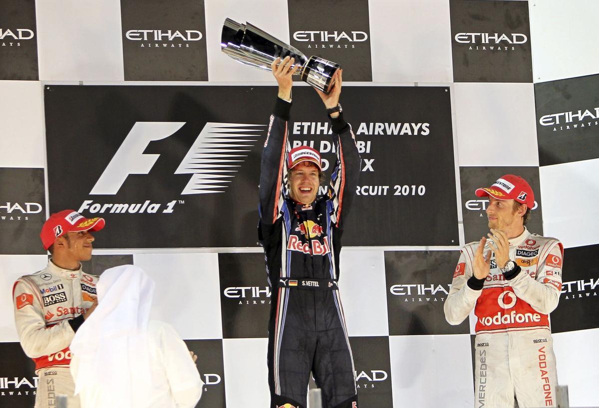 XAH45. ABU DABI (EMIRATOS ÁRABES UNIDOS), 14/11/10.- El piloto alemán de la escudería Red Bull de Fórmula Uno, Sebastian Vettel (c), celebra la victoria conseguida en el Gran Premio de Abu Dabi, disputado en el circuito de Yas Marina en Abu Dabi, Emiratos Árabes Unidos, el 14 de noviembre de 2010, junto a los británicos de McLaren Mercedes, Lewis Hamilton (izda), segundo, y Jenson Button, tercero. Vettel se ha convertido con esta victoria en el campeón más joven de la historia de la Fórmula Uno. EFE/Ali Haider. lewis hamilton - sebastian vettel - jenson button. mclaren - red bull. gp abu dhabi 2010 - mundial 2010 - campeon - celebraciones - yas marina. deportiva euforia podium trofeo 2010. yas marina