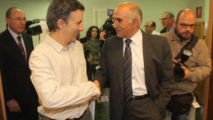 Alberto Garre (d) saluda al diputado de Podemos Antonio Urbina al llegar a la Asamblea.