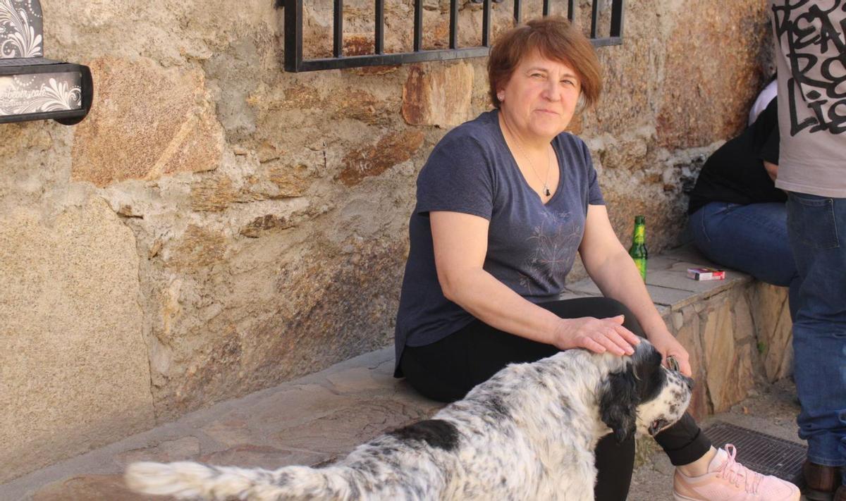 La propietaria del negocio con su perro junto a la fachada del local. | A. S.