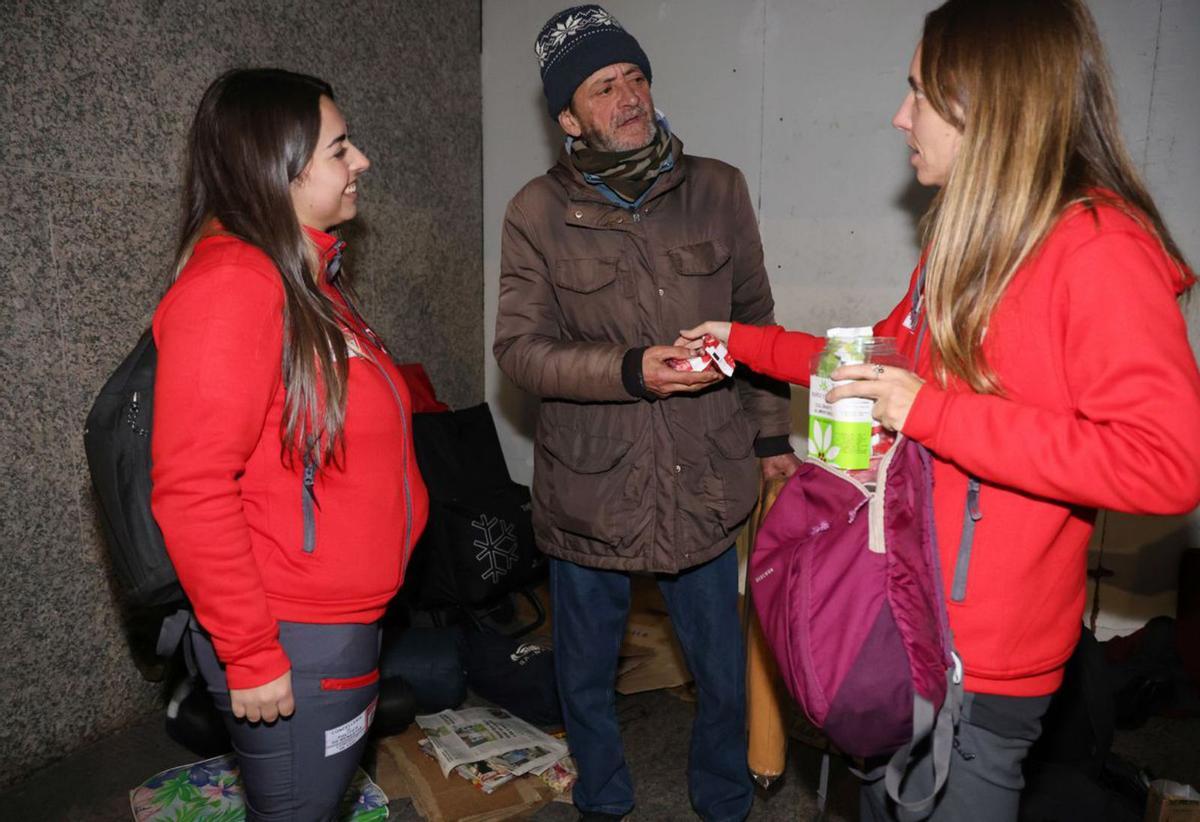 Laura y Cristina charlan con José Manuel. Personas sin hogar. Sin techo. Sinhogarismo. 16 diciembre 2023. Marta G. Brea