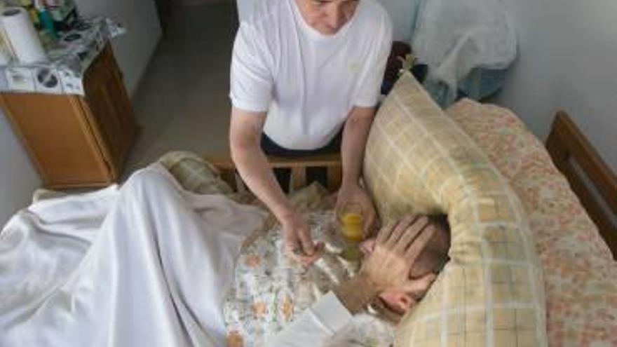 Un hombre cuidando a su familiar dependiente en una imagen de archivo.
