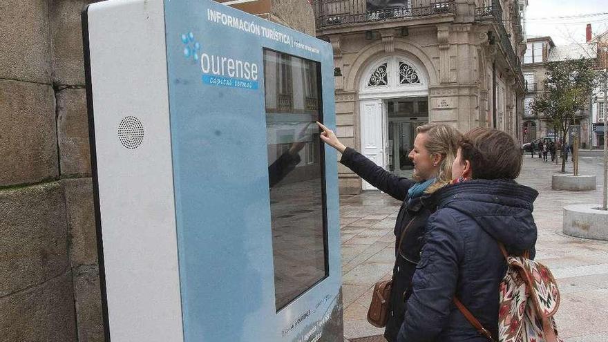 Dos turistas buscan información de la ciudad en la nueva pantalla táctil informativa. // Iñaki Osorio