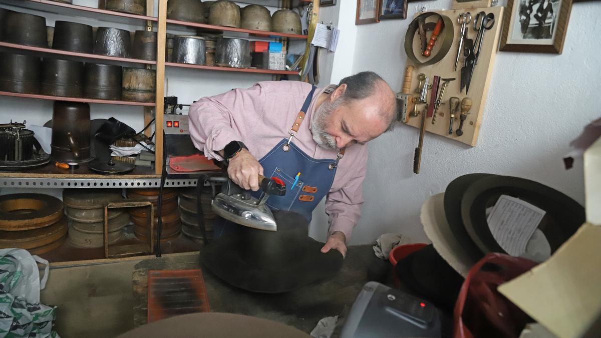 Mario Roldán plancha una campana de pelo de conejo para confeccionar un sombrero.