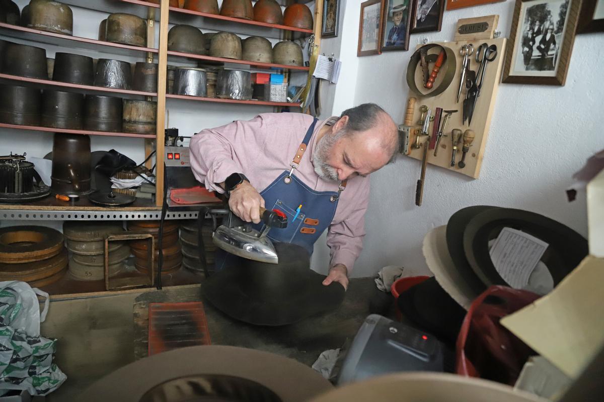 Mario Roldán plancha una campana de pelo de conejo para confeccionar un sombrero.