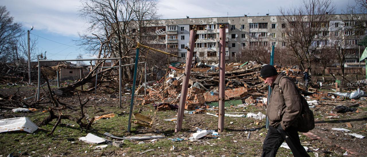 Un hombre junto a un edificio dañado por los combates en la región de Kiev