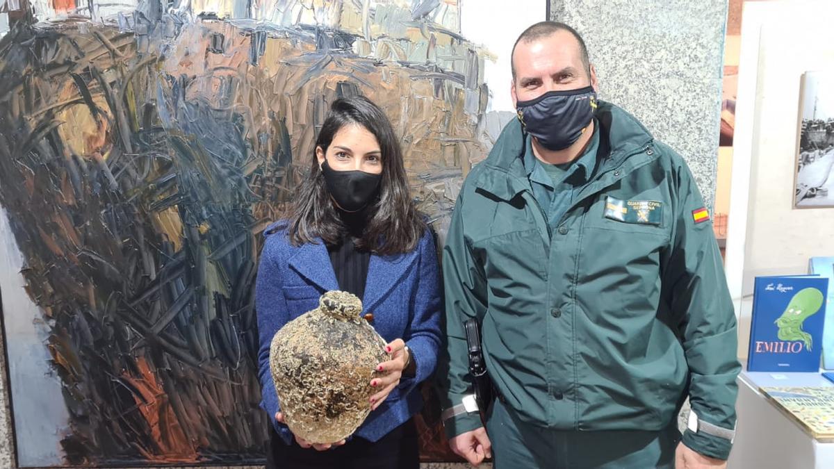 Aroa Vargas, del Museo del Mar, posa con la pieza entregada por el agente de la Guardia Civil. / FdV