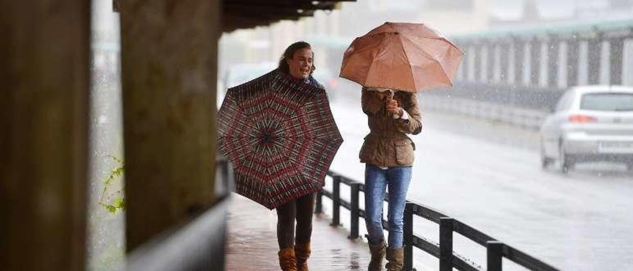 Usuarias del puente de A Barca en un día de lluvia. // Gustavo Santos