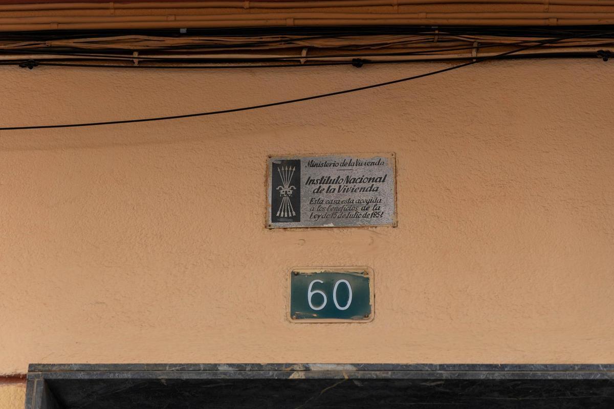 Placa del antiguo Instituto Nacional de la Vivienda con el escudo de La Falange en una calle de Alicante.