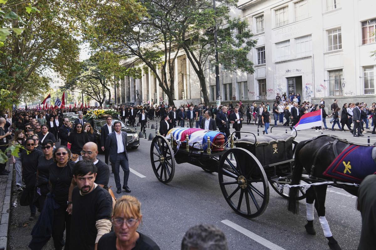 The funeral procession for the late former President Jose Mujica makes its way from the presidential palace to the National Assembly in Montevideo, Uruguay, Wednesday, May 14, 2025. (AP Photo/Matilde Campodonico)