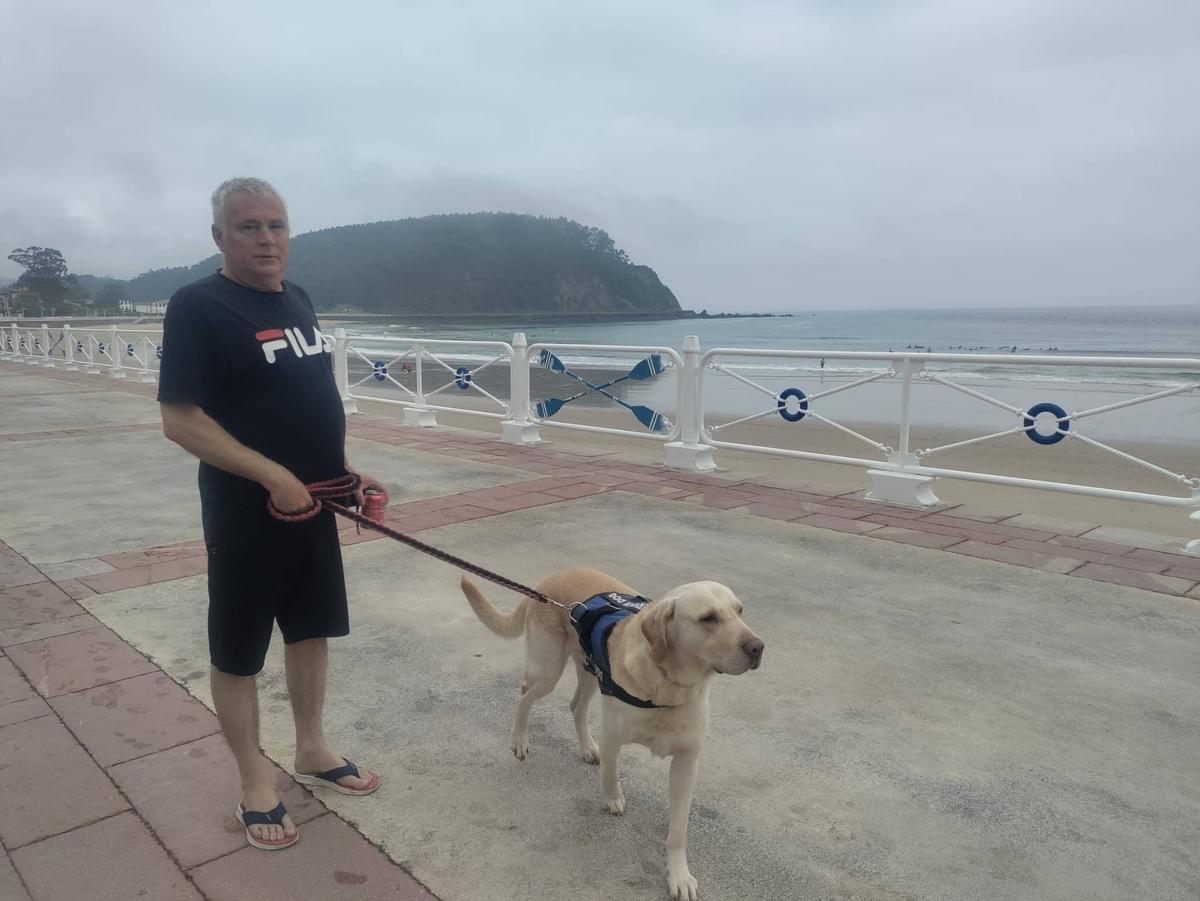 Eduardo Muñoz con su perro en el paseo de la playa de Ribadesella.