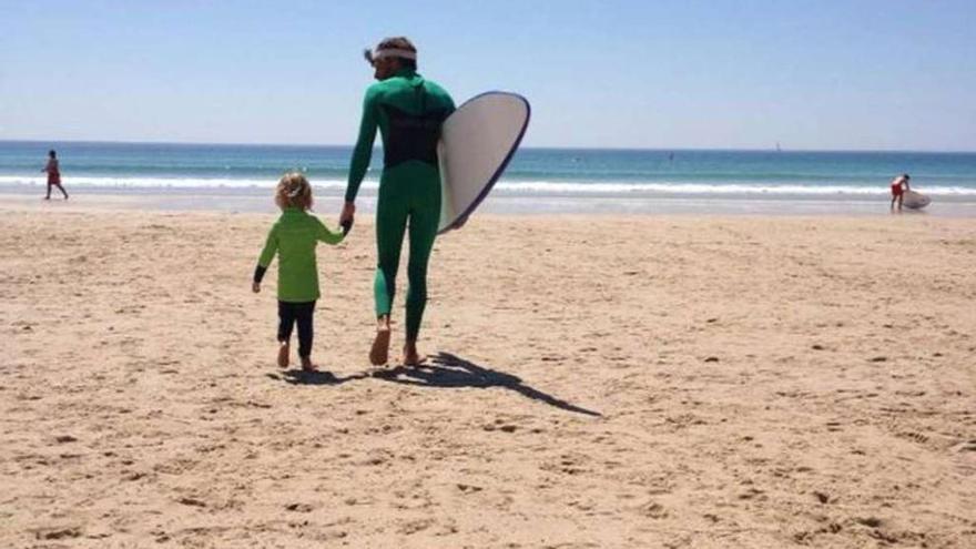 El profesor de la escuela de surf Namarea, Francisco Aller, acompaña a un alumno al agua. la opinión