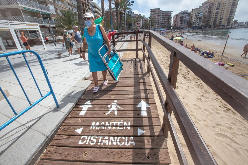 Primer día de baño autorizado en las playas de Torrevieja con arena parcelada y controles de acceso