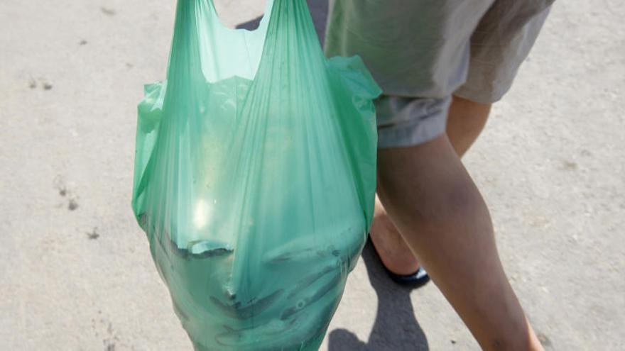 Un hombre pasea con una bolsa de plástico.