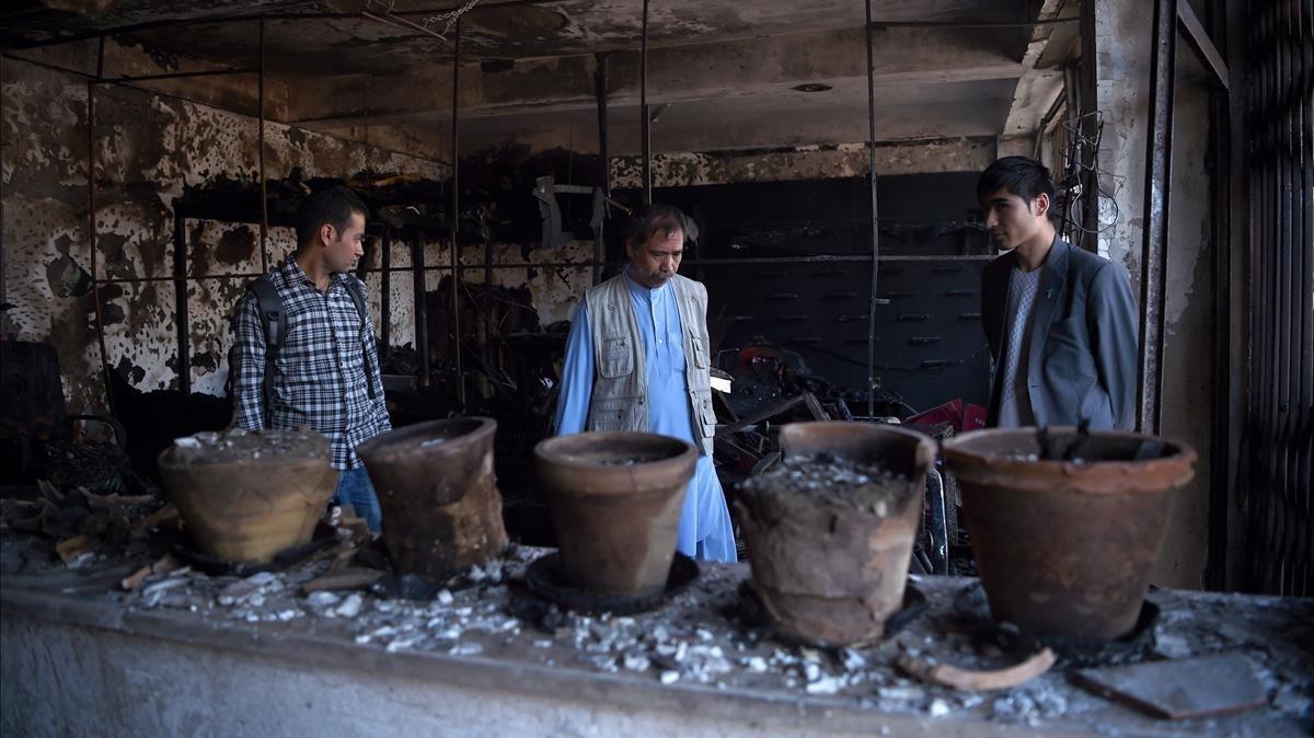 monmartinez39429743 an afghan policeman and local residents inspect a burnt shop170724094732