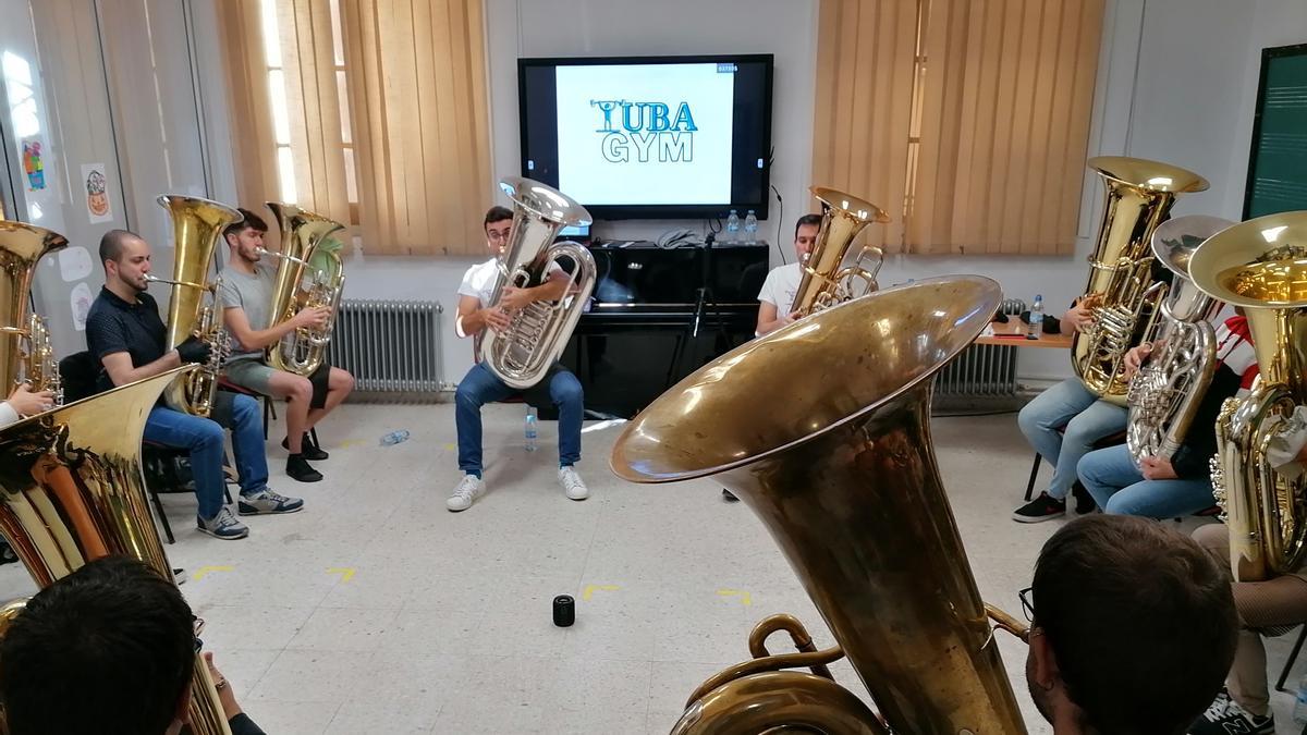 Los participantes en el encuentro practican con la tuba