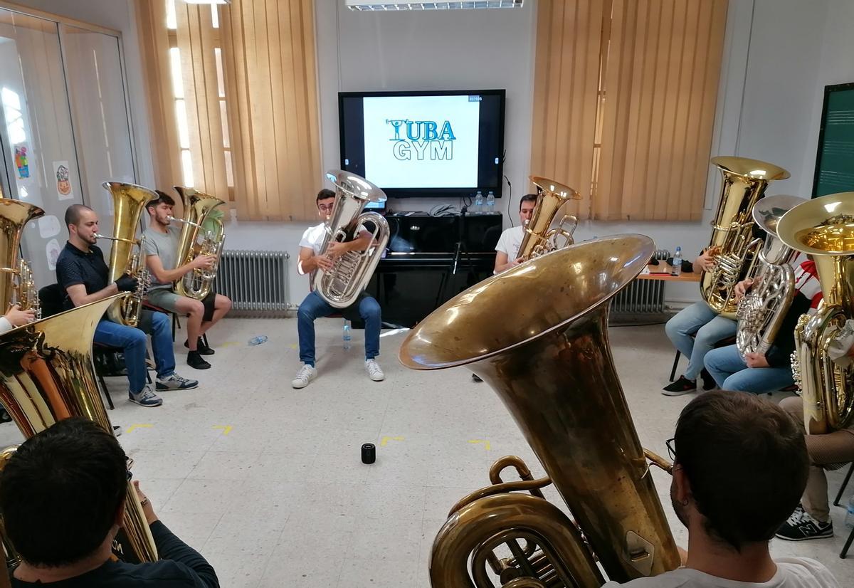 Los participantes en el encuentro practican con la tuba