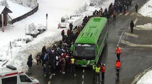 La Guardia Civil cortará los accesos a la sierra madrileña cuando los aparcamientos estén llenos. En la foto, personas atrapadas por la nieve en el puerto de Navacerrada esperan a ser evacuadas, el 2 de enero.