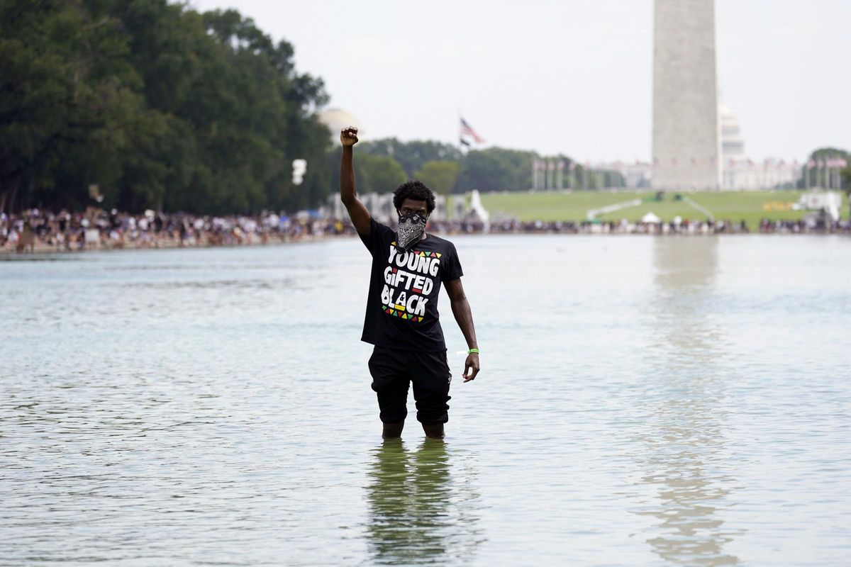 60 años de violencia racial, leyes injustas y lucha social en EEUU/ Un manifestante en mitad del lago reflectante del Mall de Washington DC en la marcha en el aniversario de la muerte de Martin Luther King Jr.