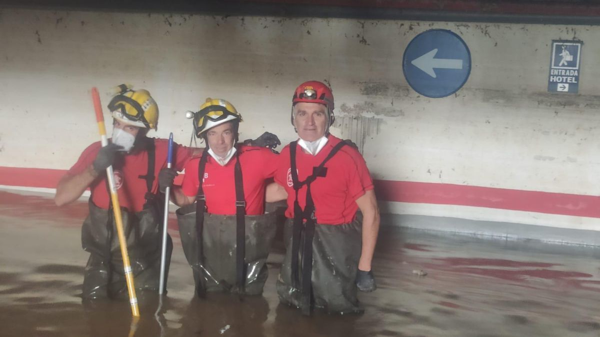 Franco, a la derecha, con dos compañeros en un parking inundado en la dana de Valencia.