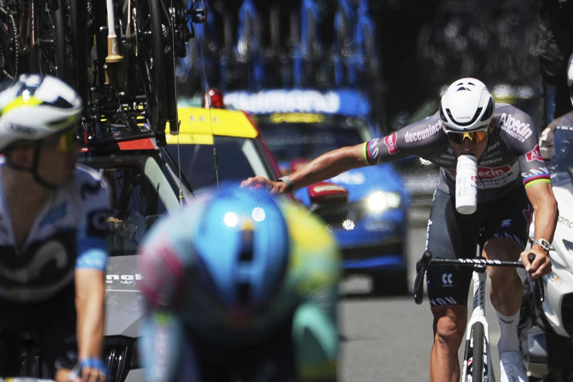 Netherlands' Mathieu van der Poel, right, takes water as he rides in the breakaway during the sixth stage of the Tour de France cycling race over 201.5 kilometers (125.2 miles) with start in Bayeux and finish in Vire Normandy, France, Thursday, July 10, 2025. (AP Photo/Thibault Camus)