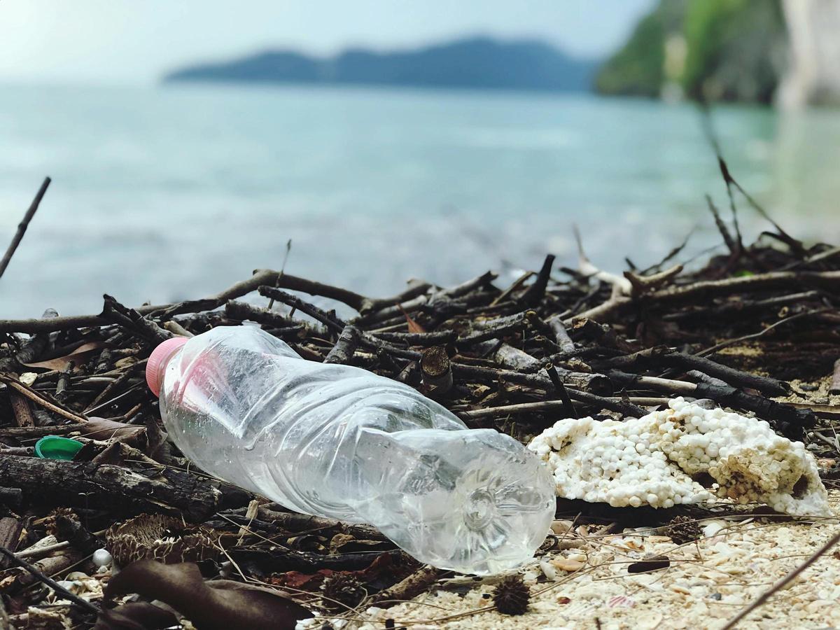 Botella vacía tirada en una playa