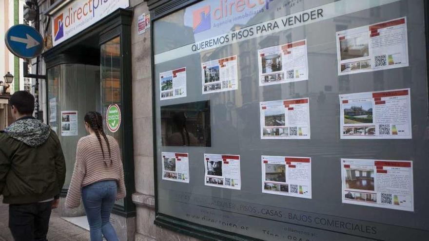 Escaparate de una inmobiliaria ovetense con varias ofertas de pisos en alquiler.