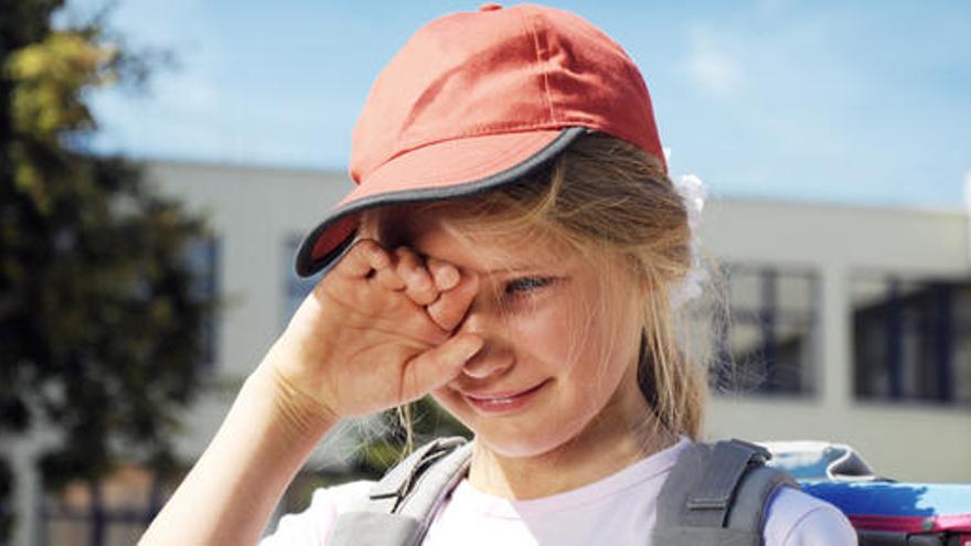 Una niña llora antes de entrar al colegio.