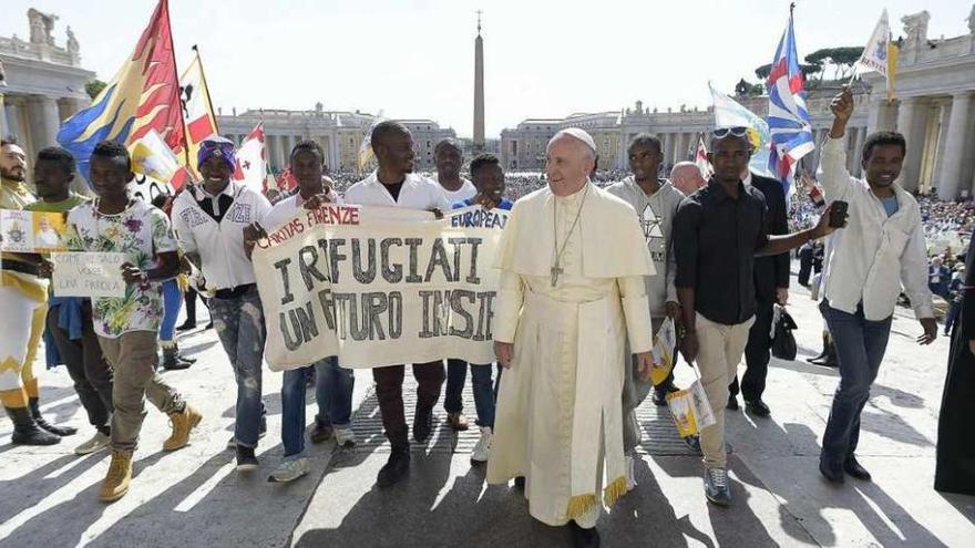 El papa Francisco junto a los refugiados, ayer, en la plaza de San Pedro del Vaticano.