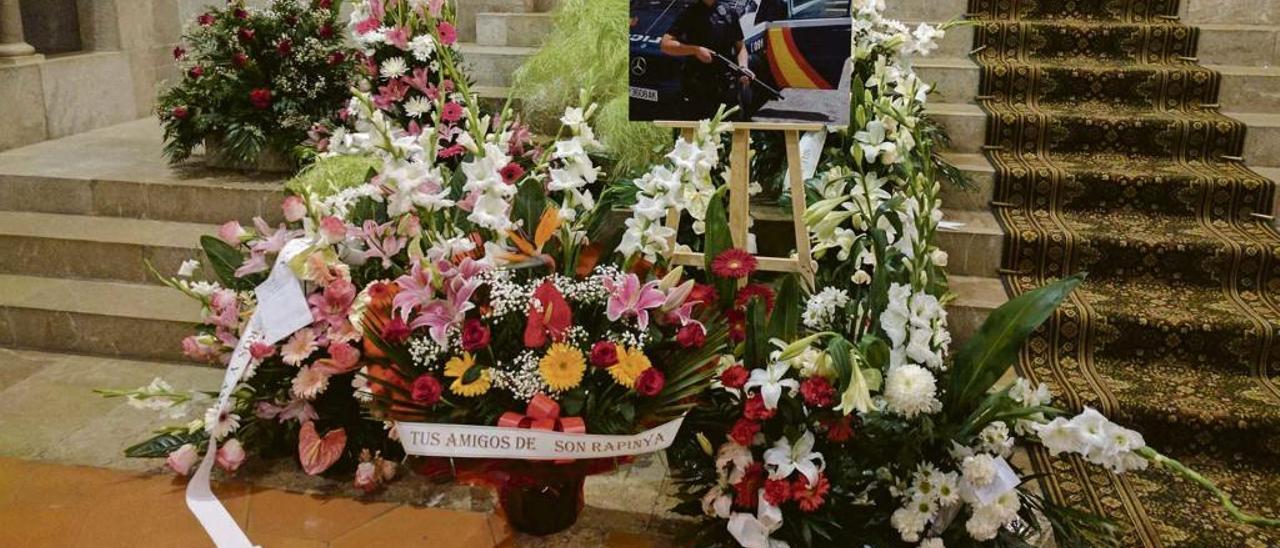 Ramos de flores alrededor de una foto de Jessica Moscoso, vestida de servicio, durante su funeral.