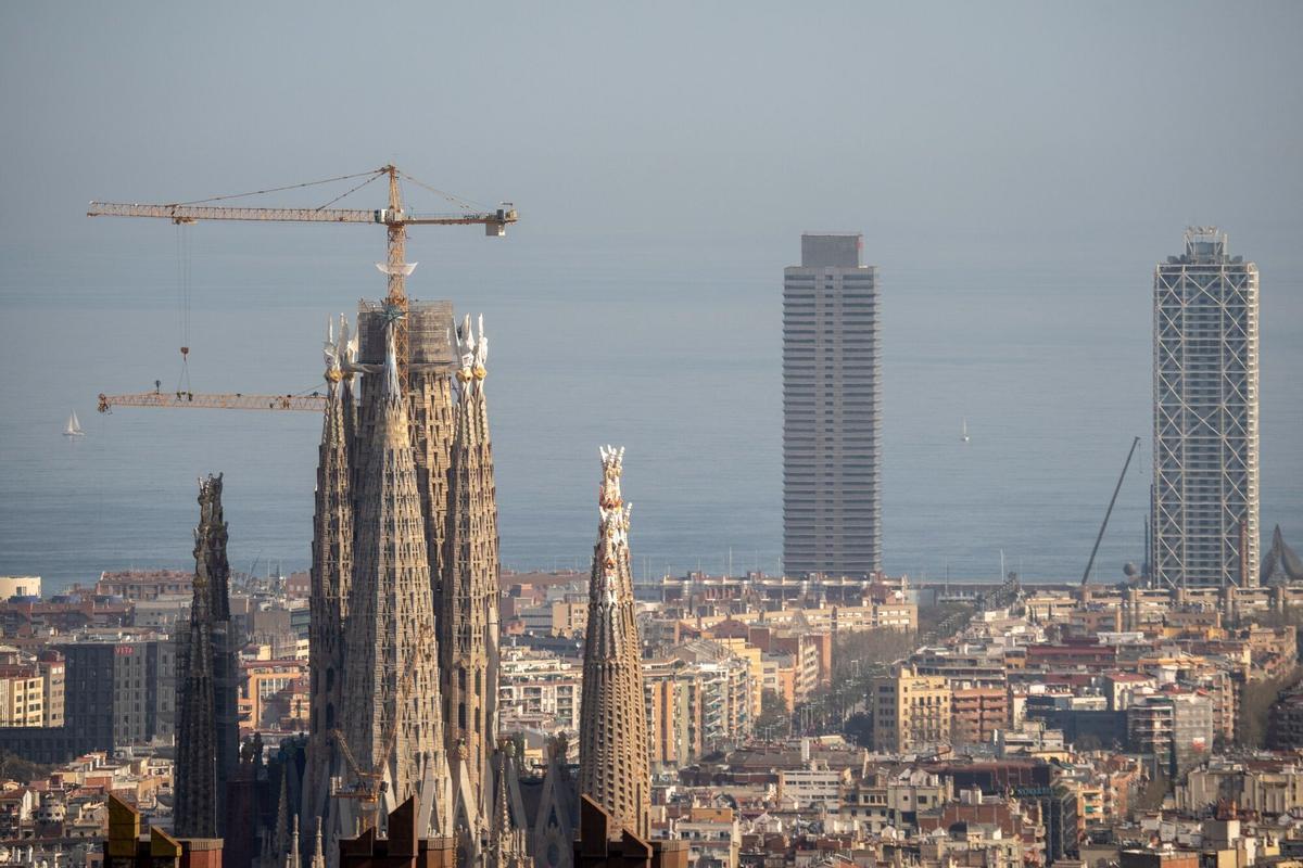 Grúas de construcción junto a la catedral de la Sagrada Familia en el horizonte de la ciudad de Barcelona.