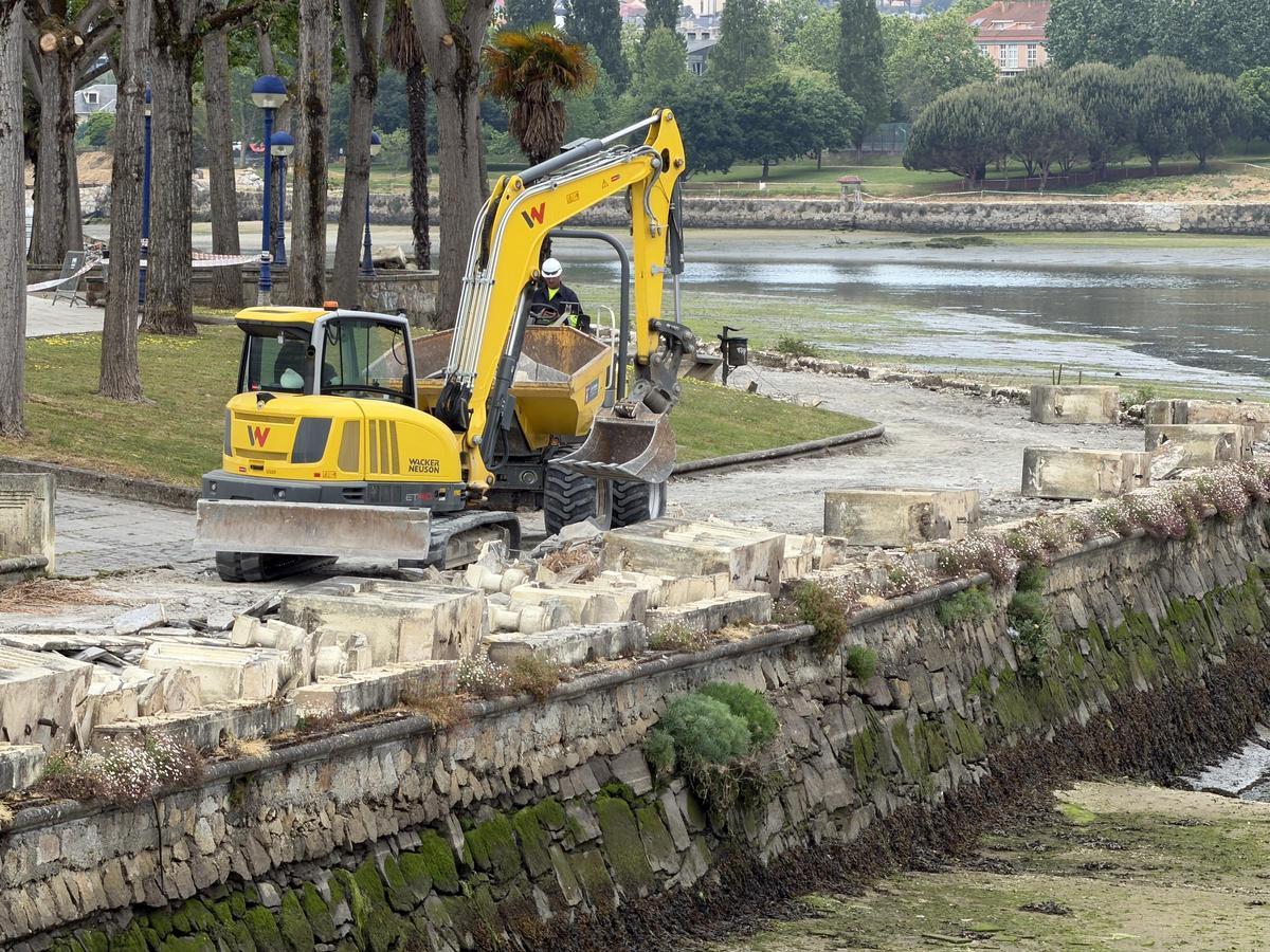 Una máquina retira la balaustrada del paseo marítimo de O Burgo, en Culleredo