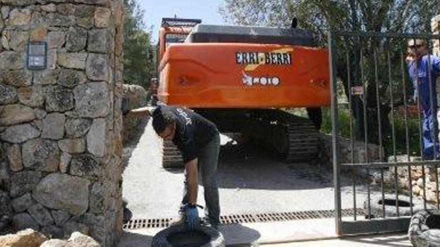 Una máquina retroexcavadora, en la entrada de la mansión.