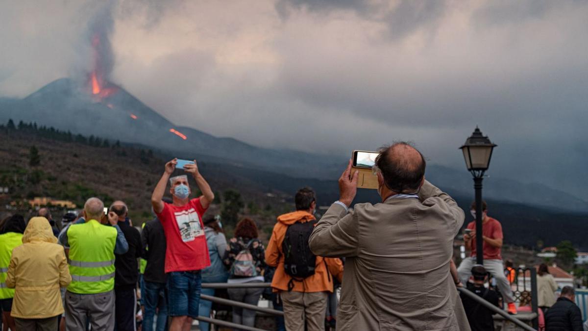 Numerosos curiosos contemplan la actividad del volcán de La Palma desde el mirador de Tajuya. |   // EFE