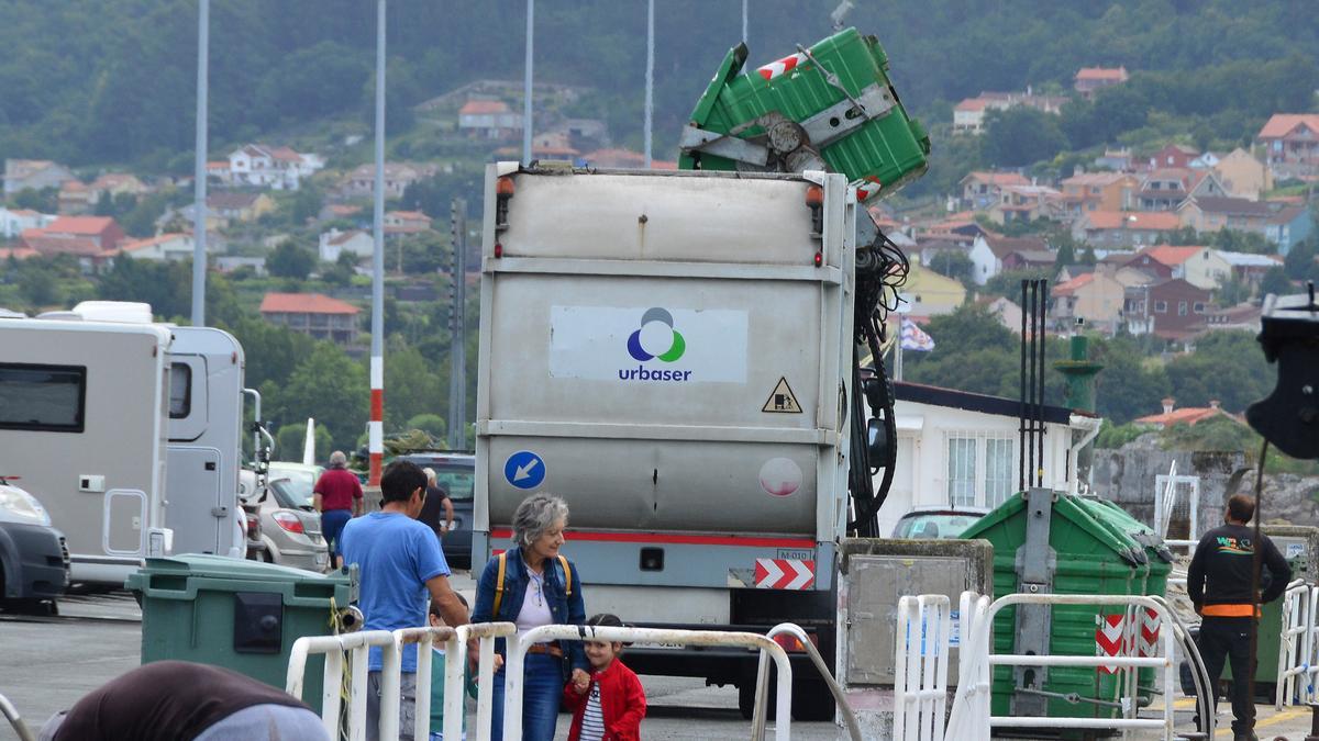 Un camión de Urbaser vacía un contenedor verde o de fracción resto en Bueu.