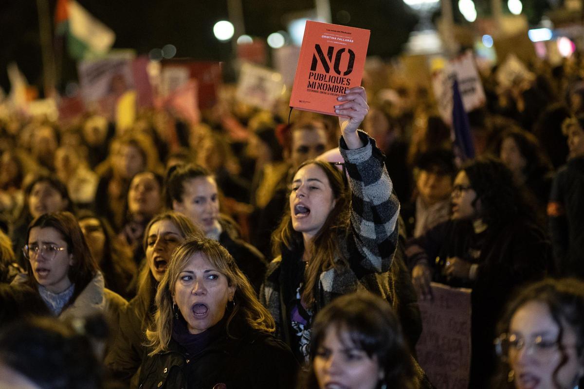 Archivo - Una mujer levanta un libro durante la manifestación organizada por la Comisión 8M con motivo del 25N y bajo el lema "Juntas, el miedo cambia de bando".