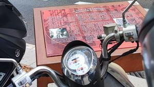 El atril en memoria de la represión en Via Laietana, girado y escondido entre motos