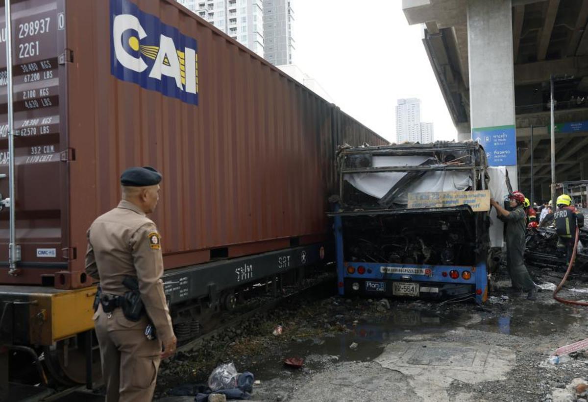 Imágenes del accidente entre un tren y un autobús en Bangkok, que ha dejado al menos ocho muertos y 25 heridos después de que el vehículo se incendiara tras el impacto.